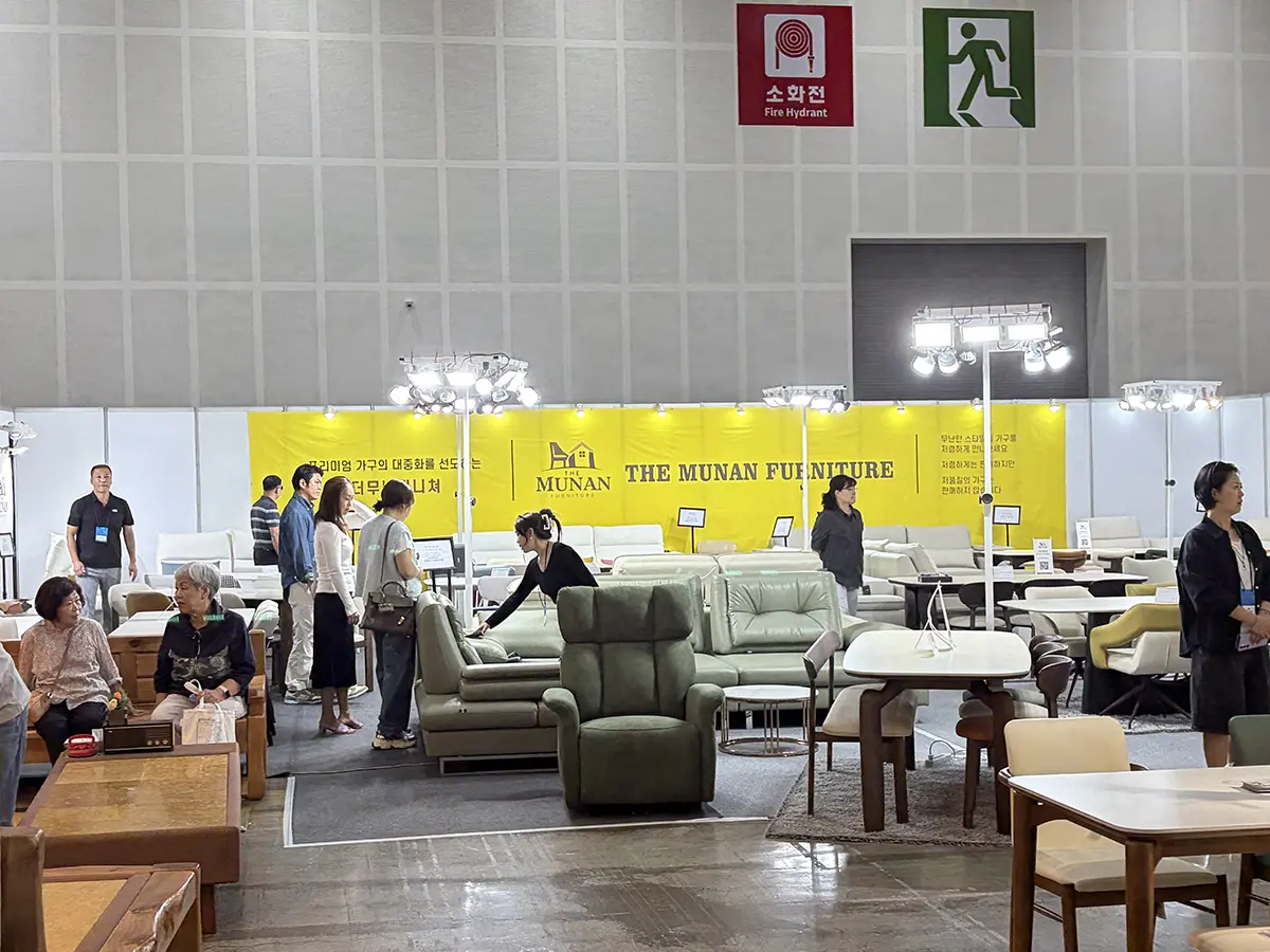 Indoor furniture showroomexhibition with sofas and tables a bright yellow banner reads THE MUNAN FURNITURE in the background