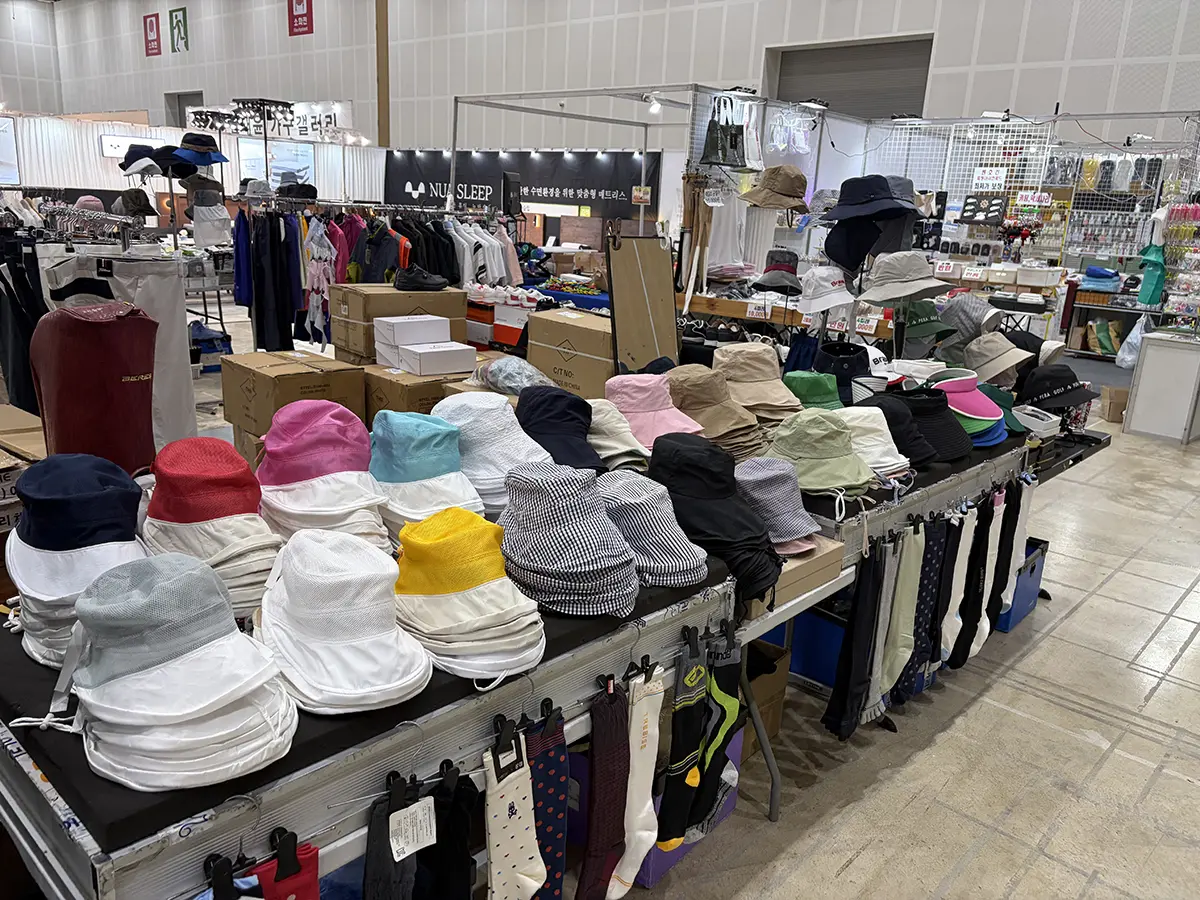 Row of colorful bucket hats stacked on a long table at an indoor market stall