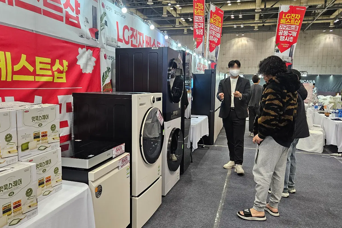 수원가구엑스포전시스케치06 수원 가구엑스포 Trade show booth displaying LG washing machines and a dryer red banners and product boxes nearby attendees wearing masks